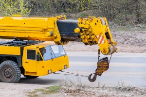 A yellow automobile mobile crane parked along a road.